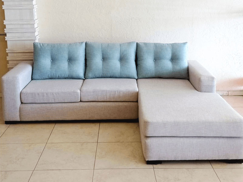 Esquinero moderno cuerpo tapizado color hueso almohadones estilo capitoné color azul pálido