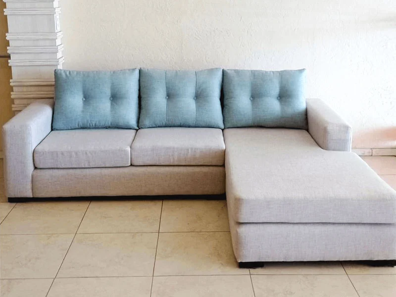 Esquinero moderno cuerpo tapizado color hueso almohadones estilo capitoné color azul pálido
