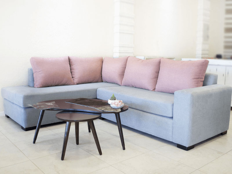 Esquinero Moderno tapizado cuerpo de color azul pálido y almohadones color rosa viejo